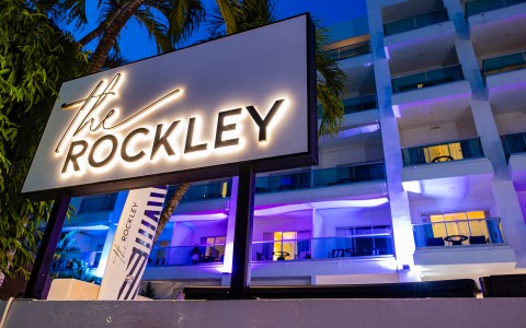 a sign with a palm tree in front of a building
