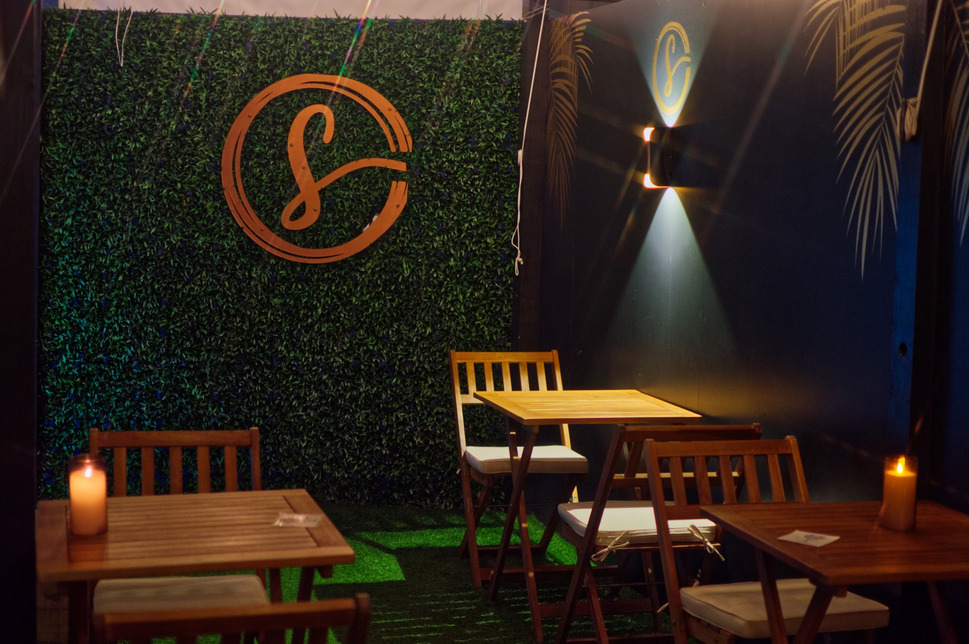 a table and chairs in a room with a green wall and a logo