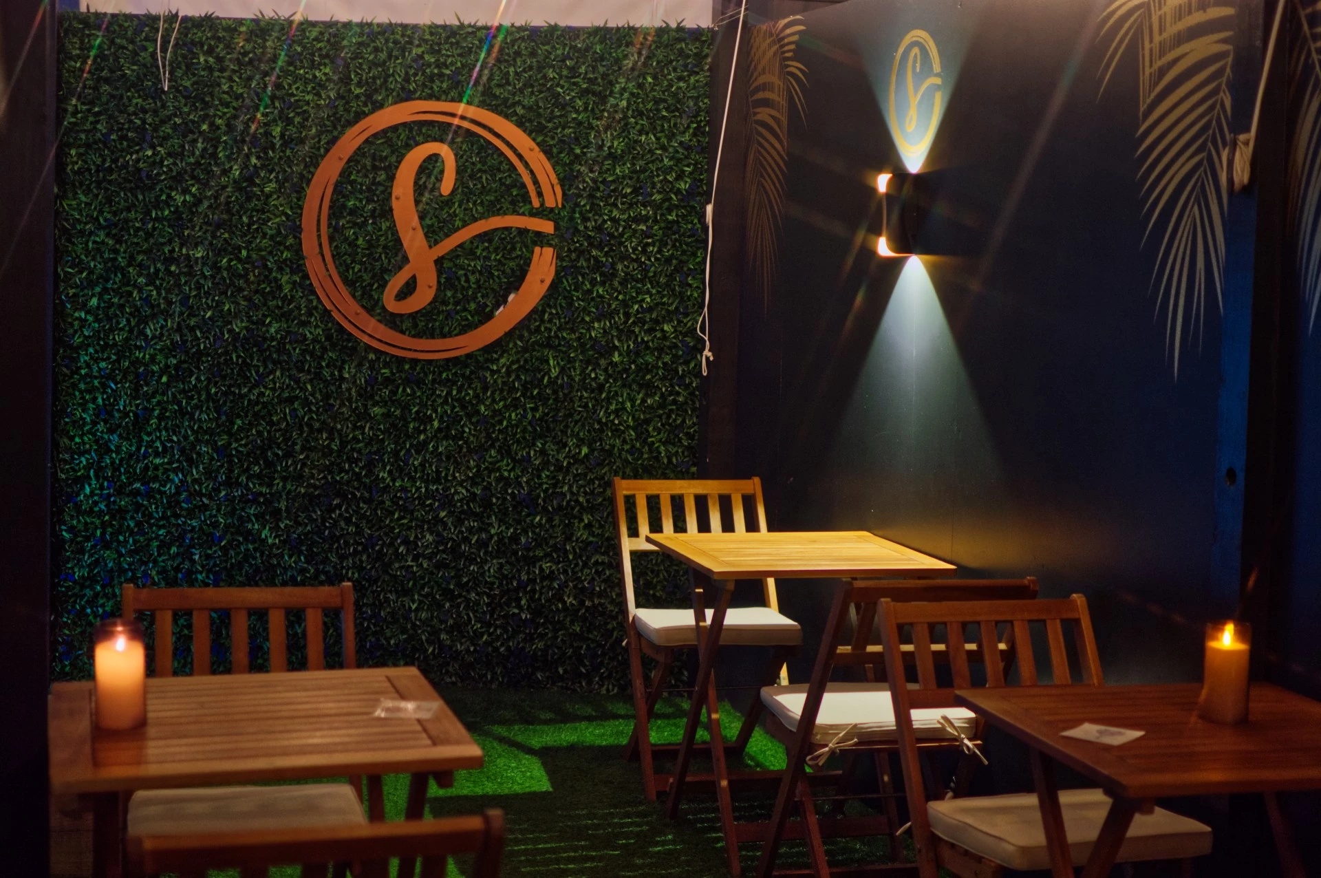 a table and chairs in a room with a green wall and a logo