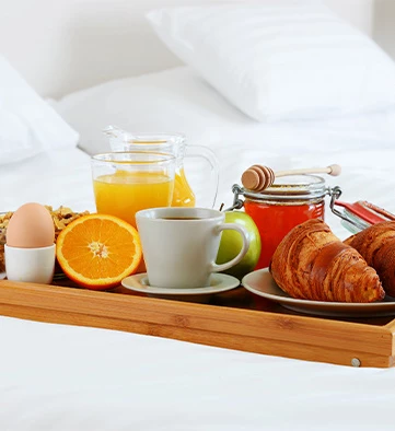 a wooden tray with breakfast foods on it