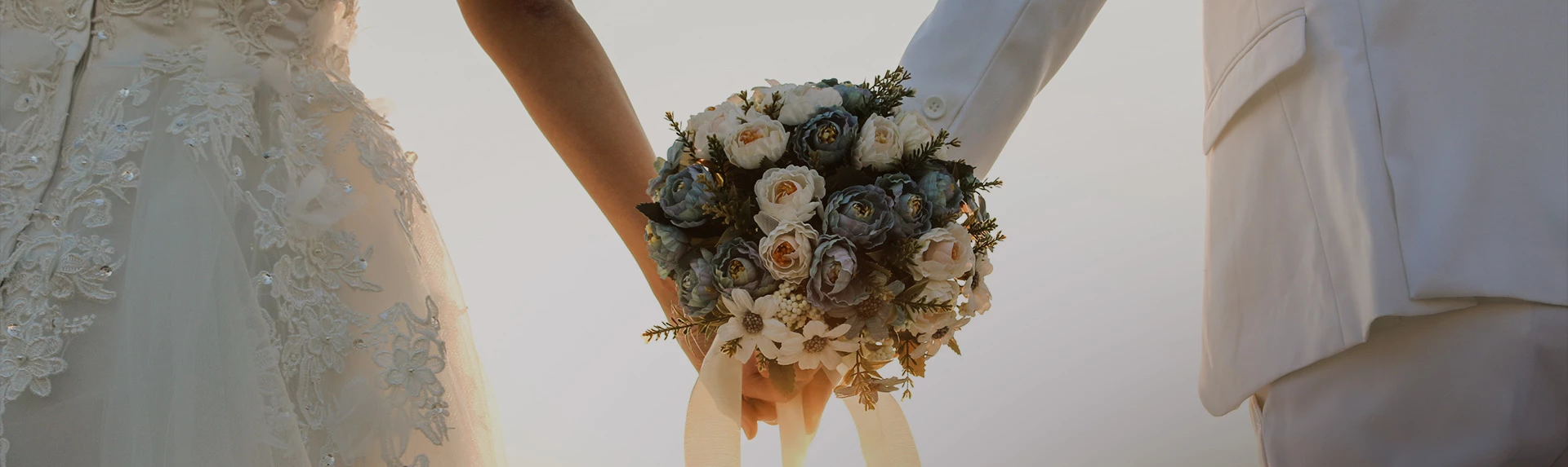a bride and groom holding a bouquet of flowers