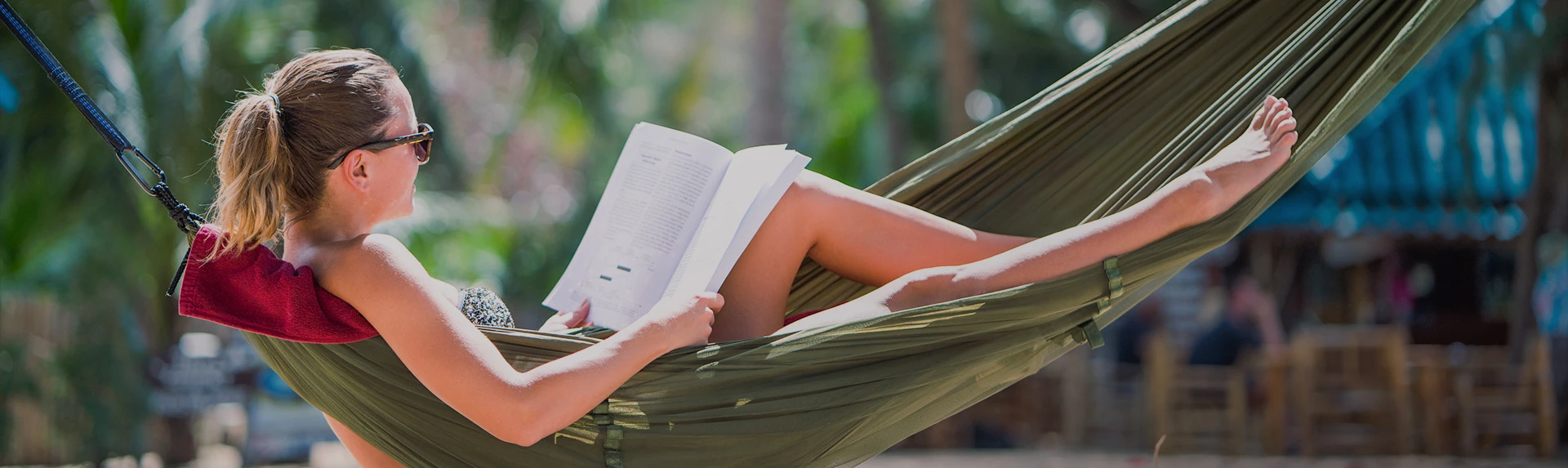 a person reading a book on a hammock