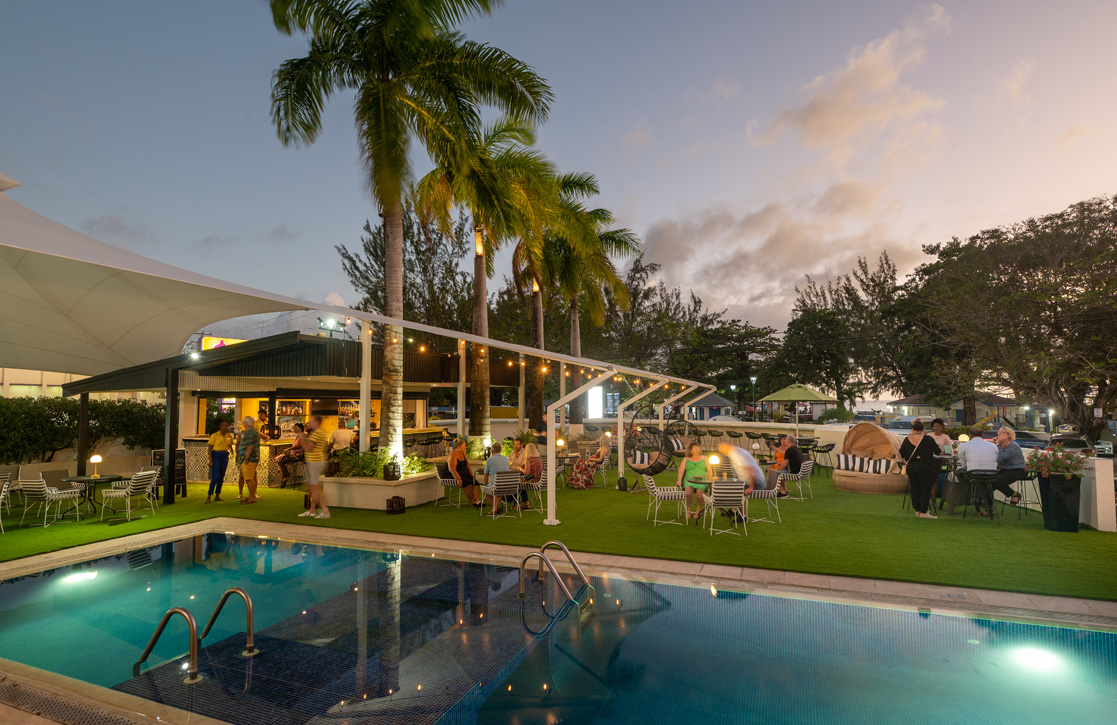 a pool and palm trees with people around it