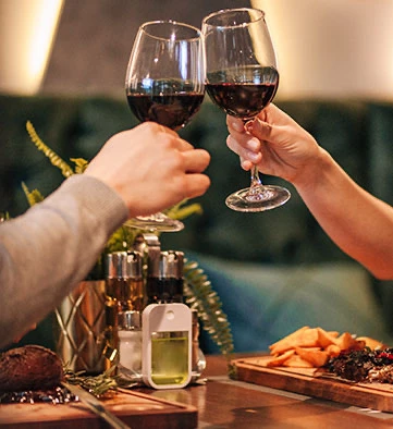 two people clinking two glasses of wine together