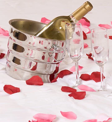 a glass of champagne in a bucket with two glasses next to it