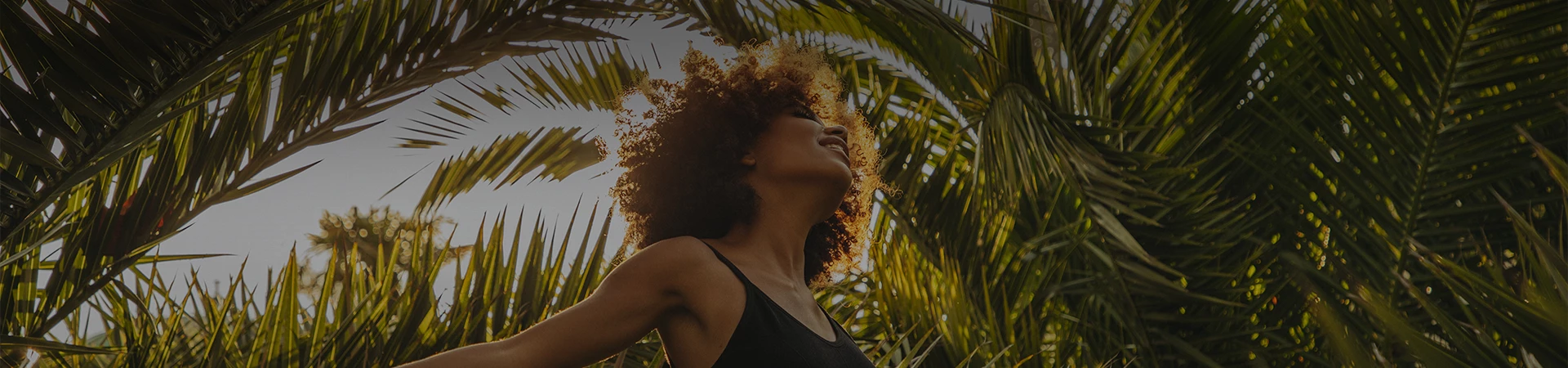 a woman with curly hair and a palm tree