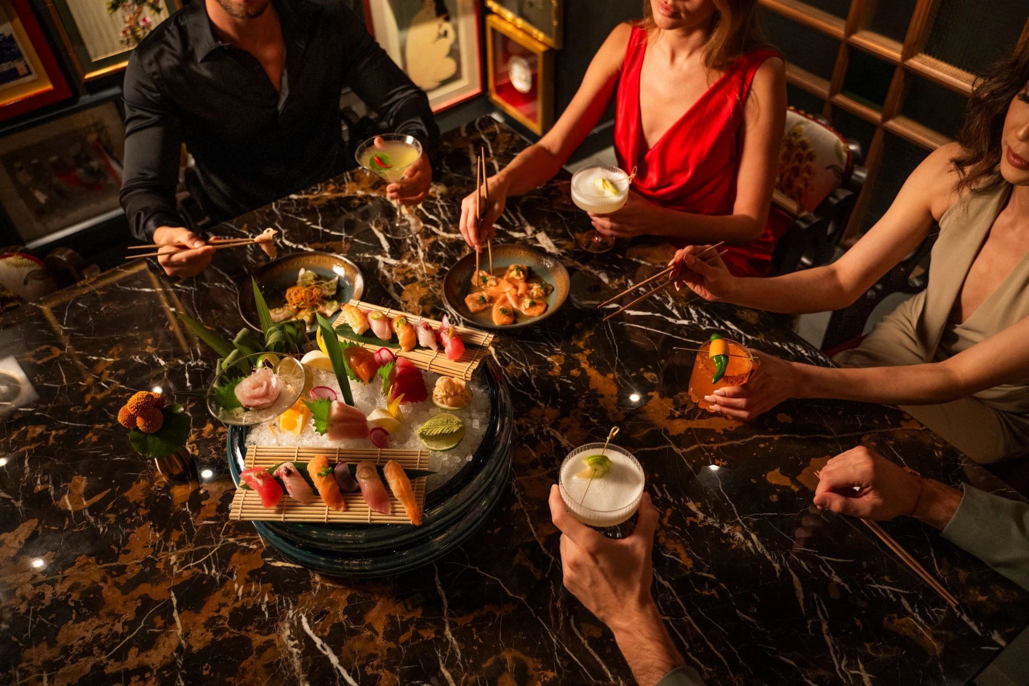 a group of people sitting around a table with food
