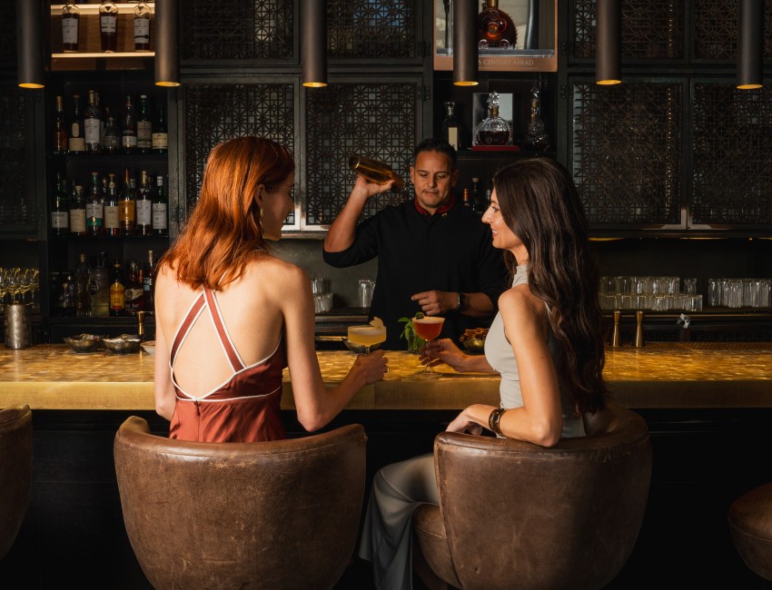 a group of women sitting at a bar