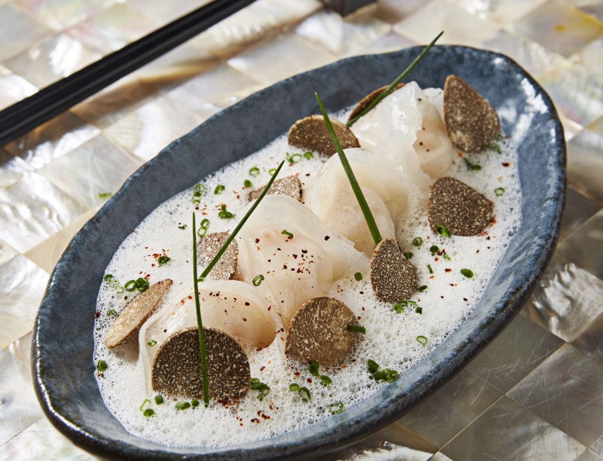 blue dish filled with dumplings and shaved truffles