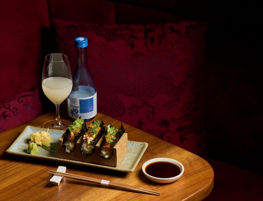 a plate of sushi and a glass of wine on a table