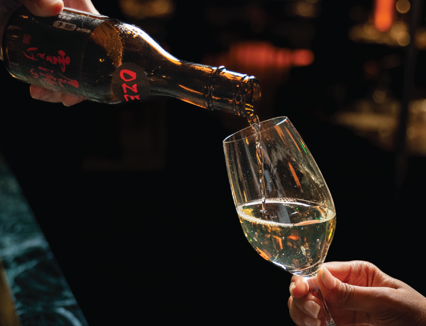 a person pouring a glass of wine