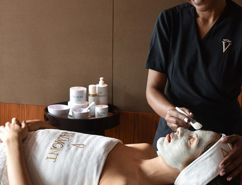 a relaxed woman receiving a facial mask