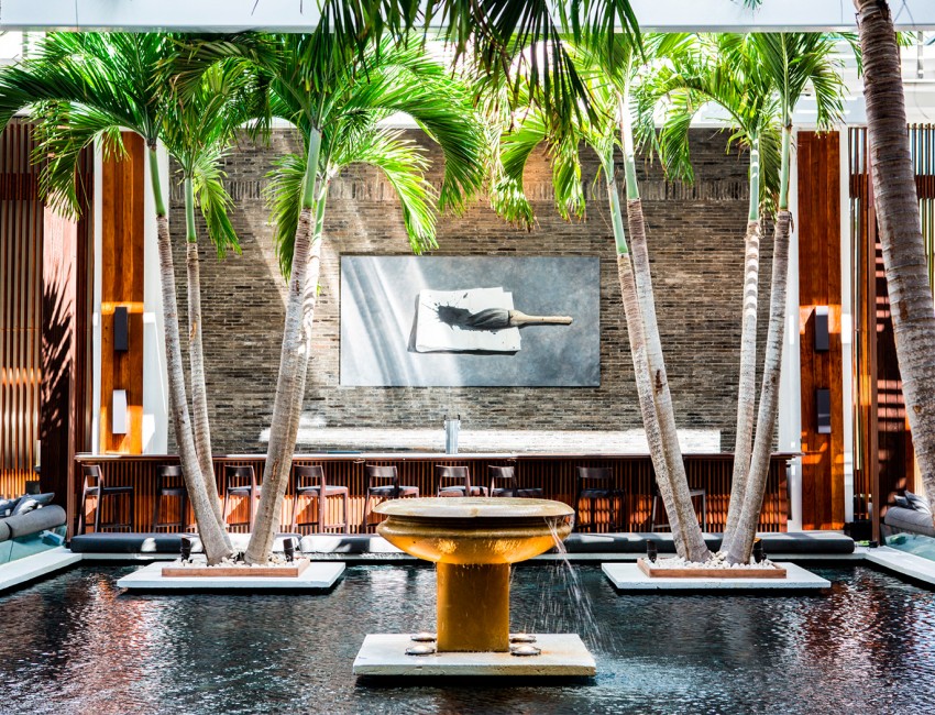 a large fountain with palm trees and a bar in the background