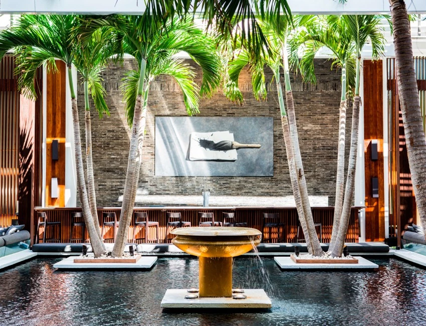 a large fountain with palm trees and a bar in the background