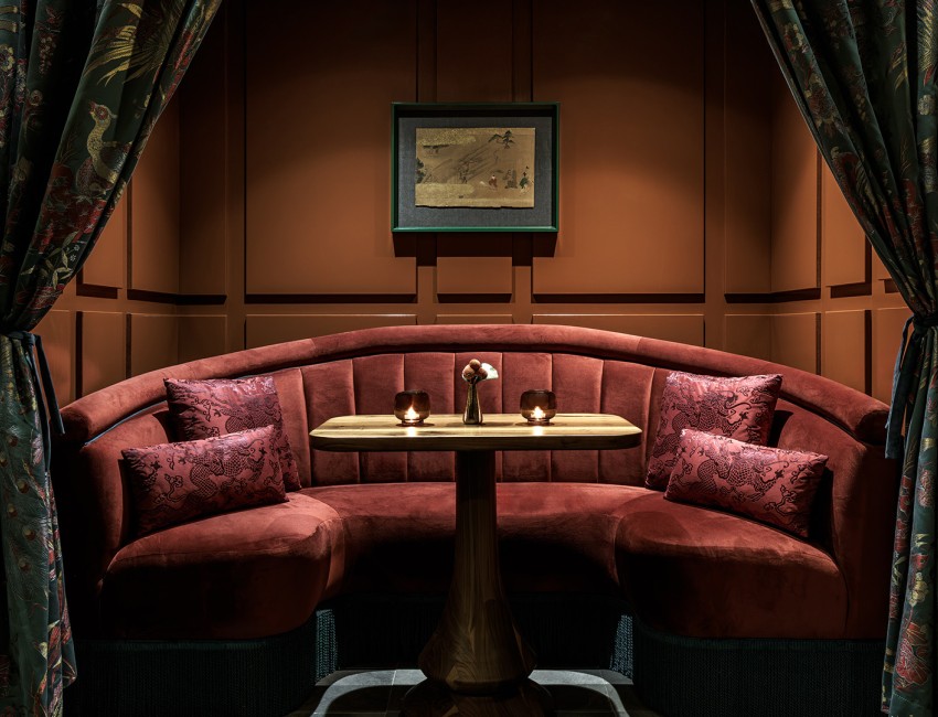 a booth seating with a table and a picture on the wall