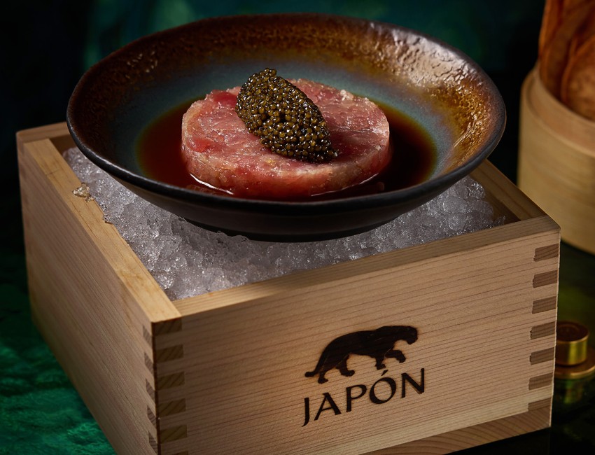 a bowl of meat with caviar on ice