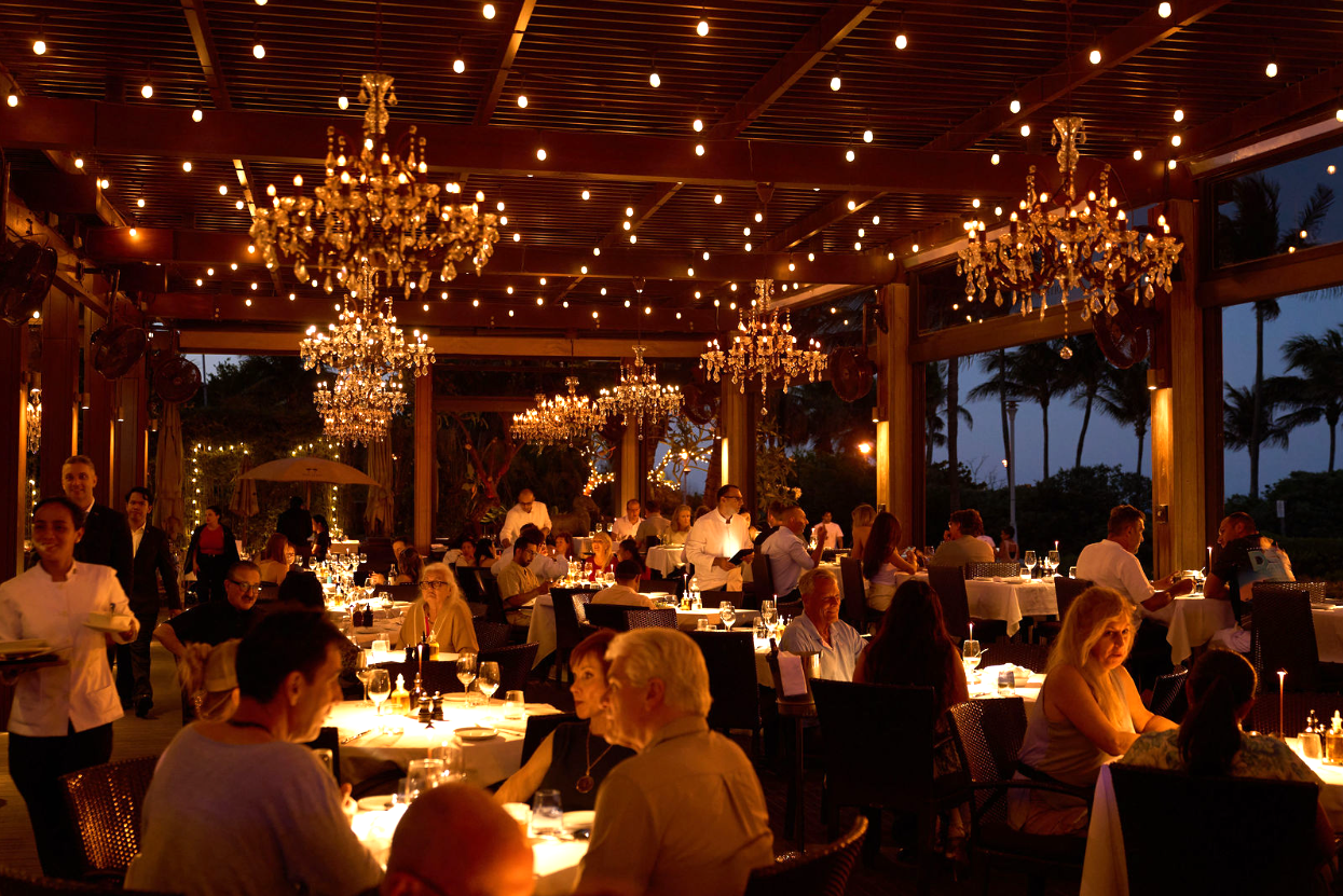 a group of people sitting at tables in a restaurant