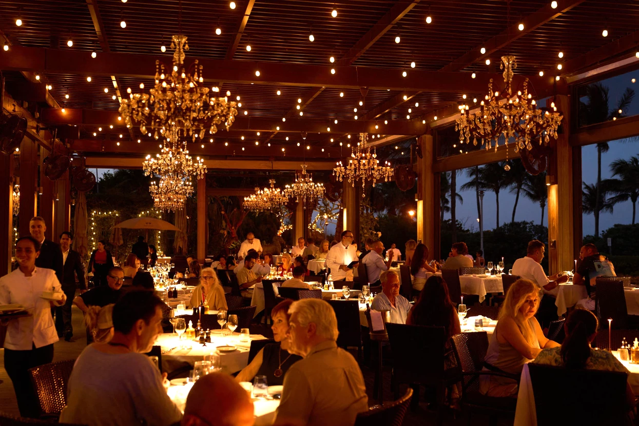 a group of people sitting at tables in a restaurant