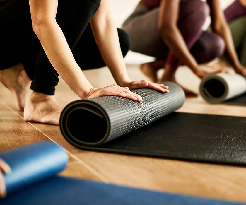 a group of people rolling up their yoga mats