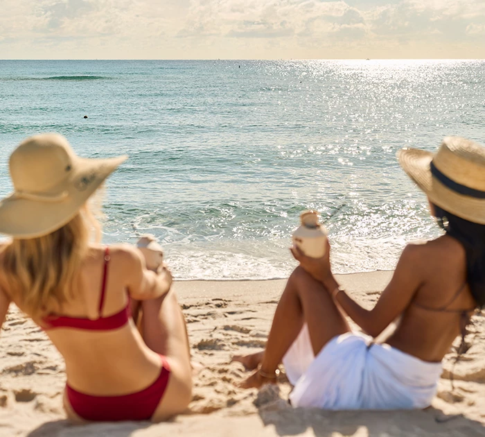 two women sitting on a beach