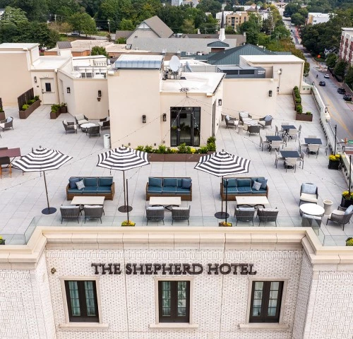 a rooftop of a hotel with chairs and umbrellas