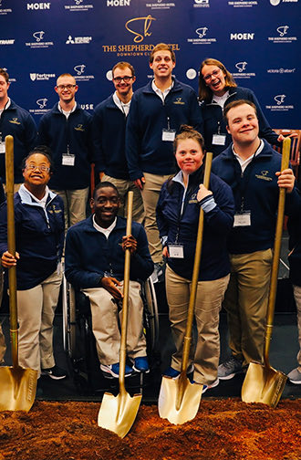group of people holding shovels smiling