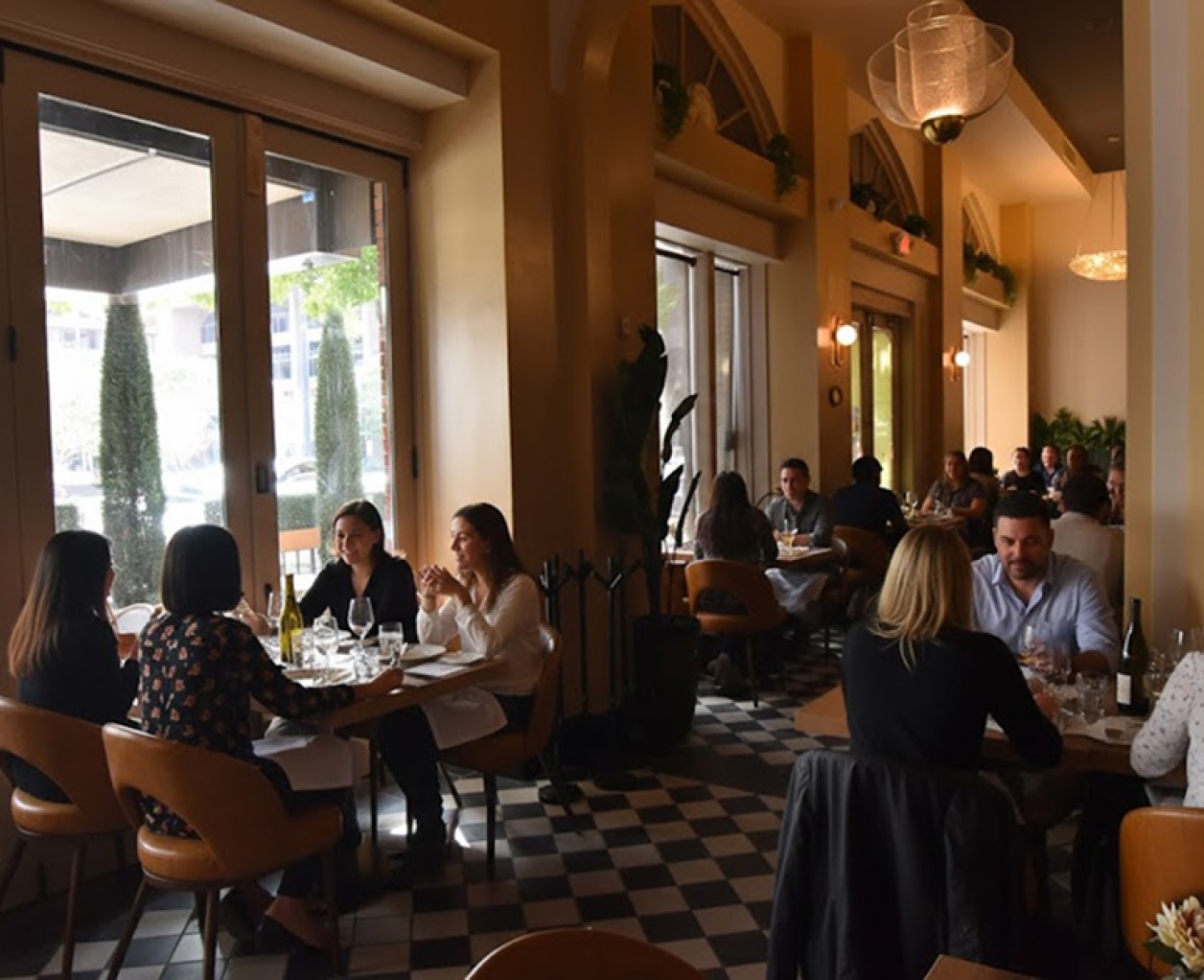 a group of people sitting at tables in a restaurant