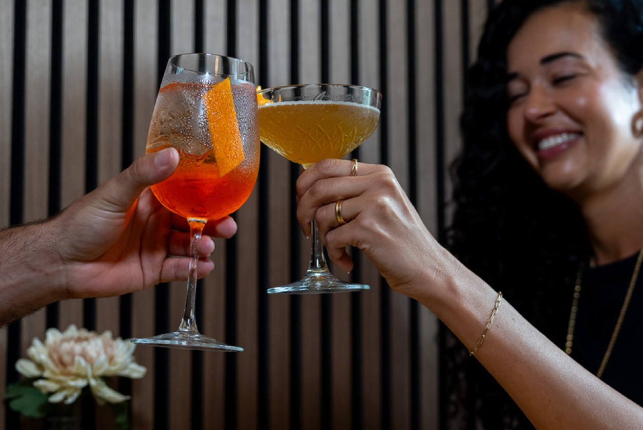 a woman holding up a glass of alcohol