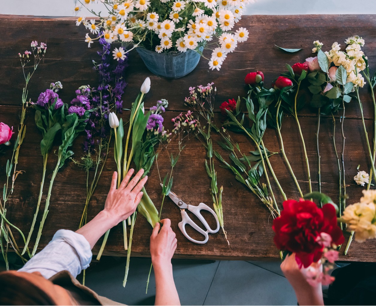 a person holding flowers on a table