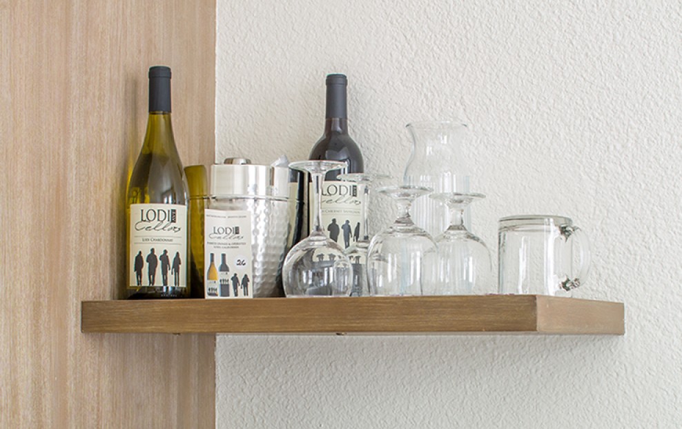 a shelf with wine bottles and glasses