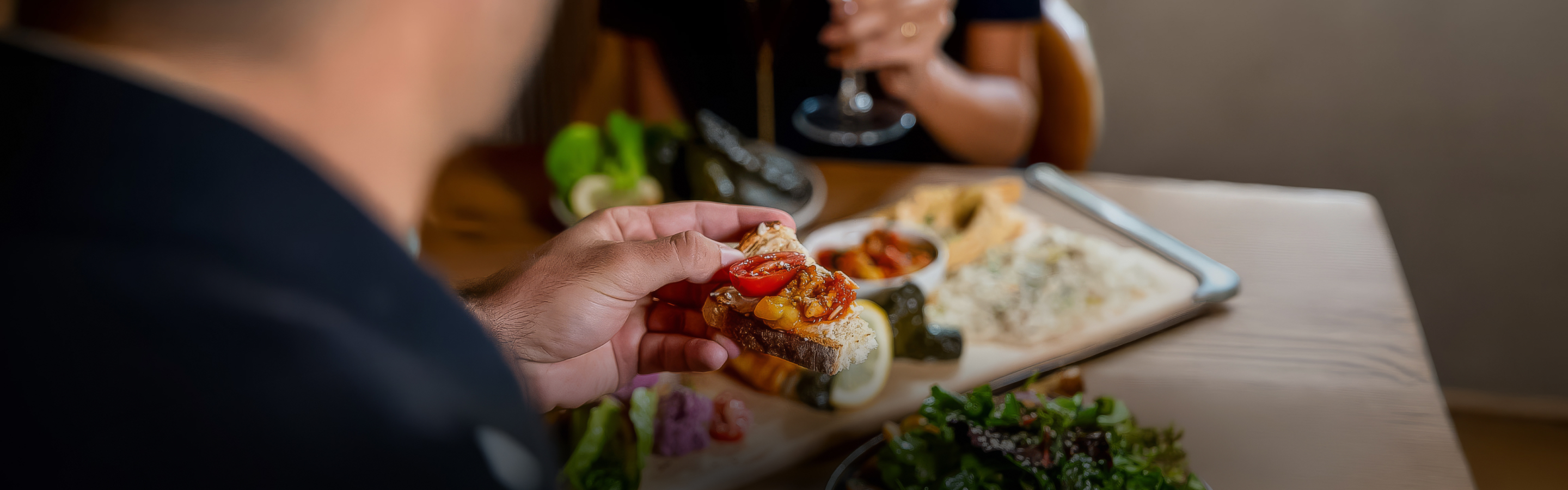 a person holding a piece of bread with tomatoes on it
