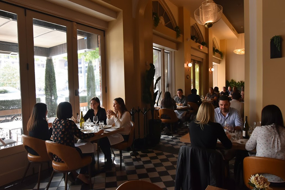 a group of people sitting at tables in a restaurant
