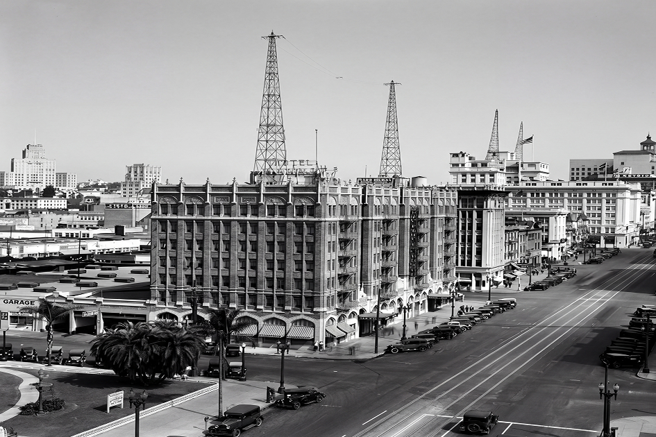 a black and white photo of a street with cars and buildings