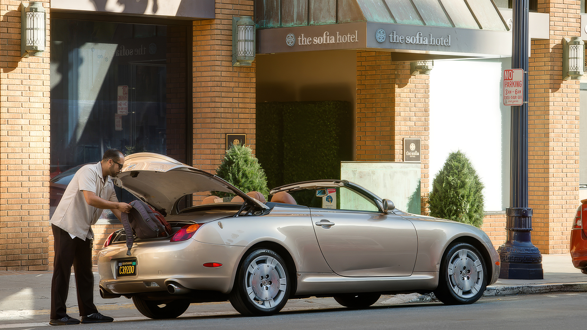 a man sitting in the trunk of a convertible car