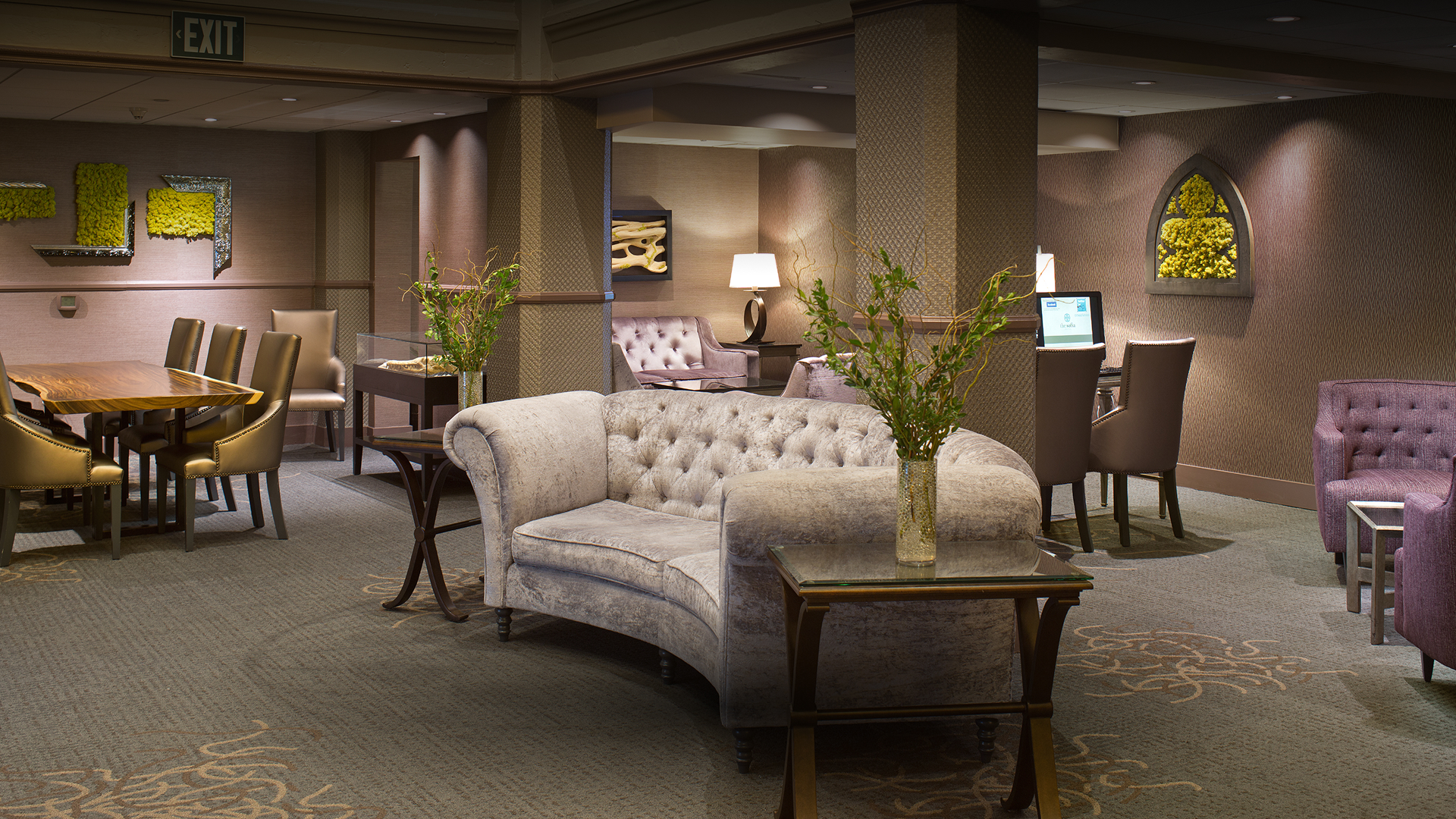 a room with a couch and a vase of flowers