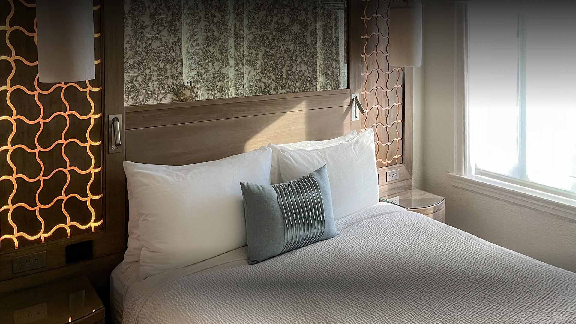 a bed with pillows and a lamp