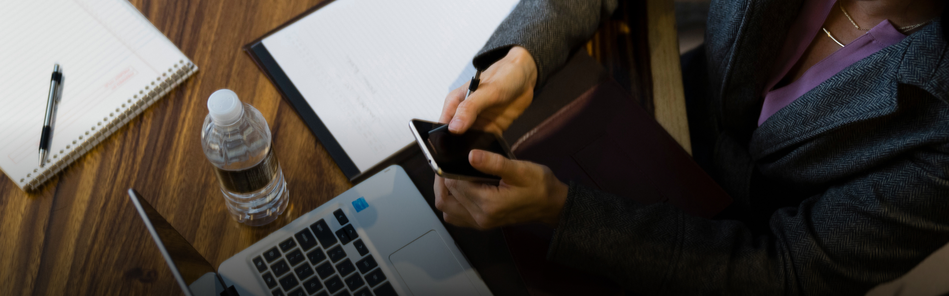 a person holding a phone and a pen