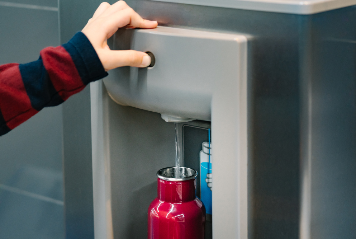 a hand pushing a red can into a cooler