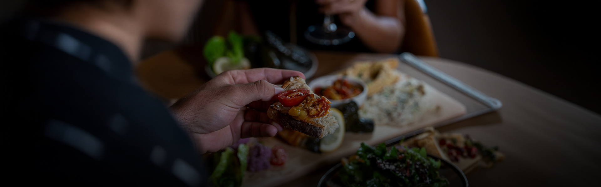 a person holding a piece of bread with tomatoes on it