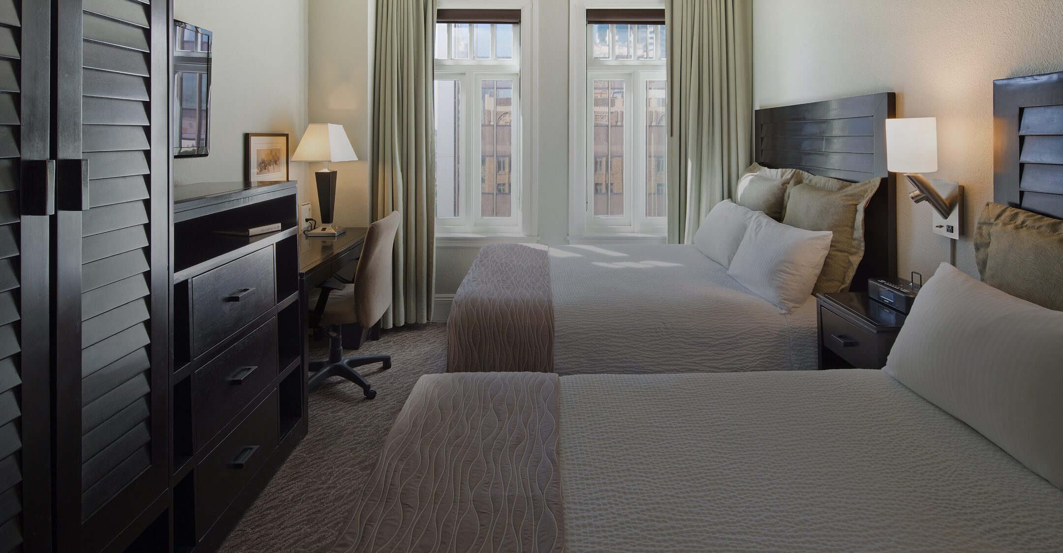 a room with two beds and a desk
