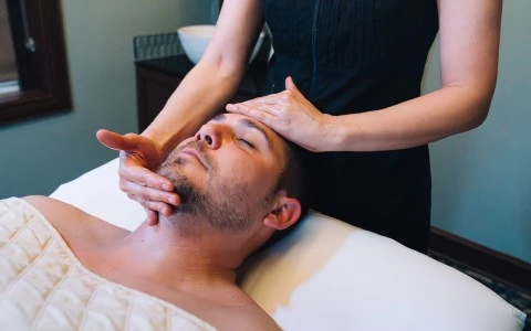 a man lying down on a bed with his hands on his head