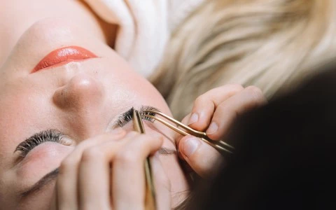 a woman getting eyelash extensions done