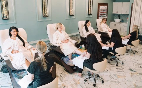 a group of women sitting in chairs in a beauty salon