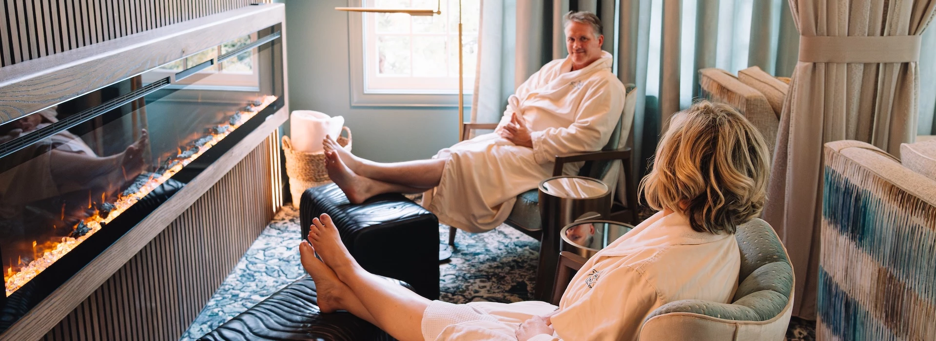a man in a white robe sitting in a chair with his feet up