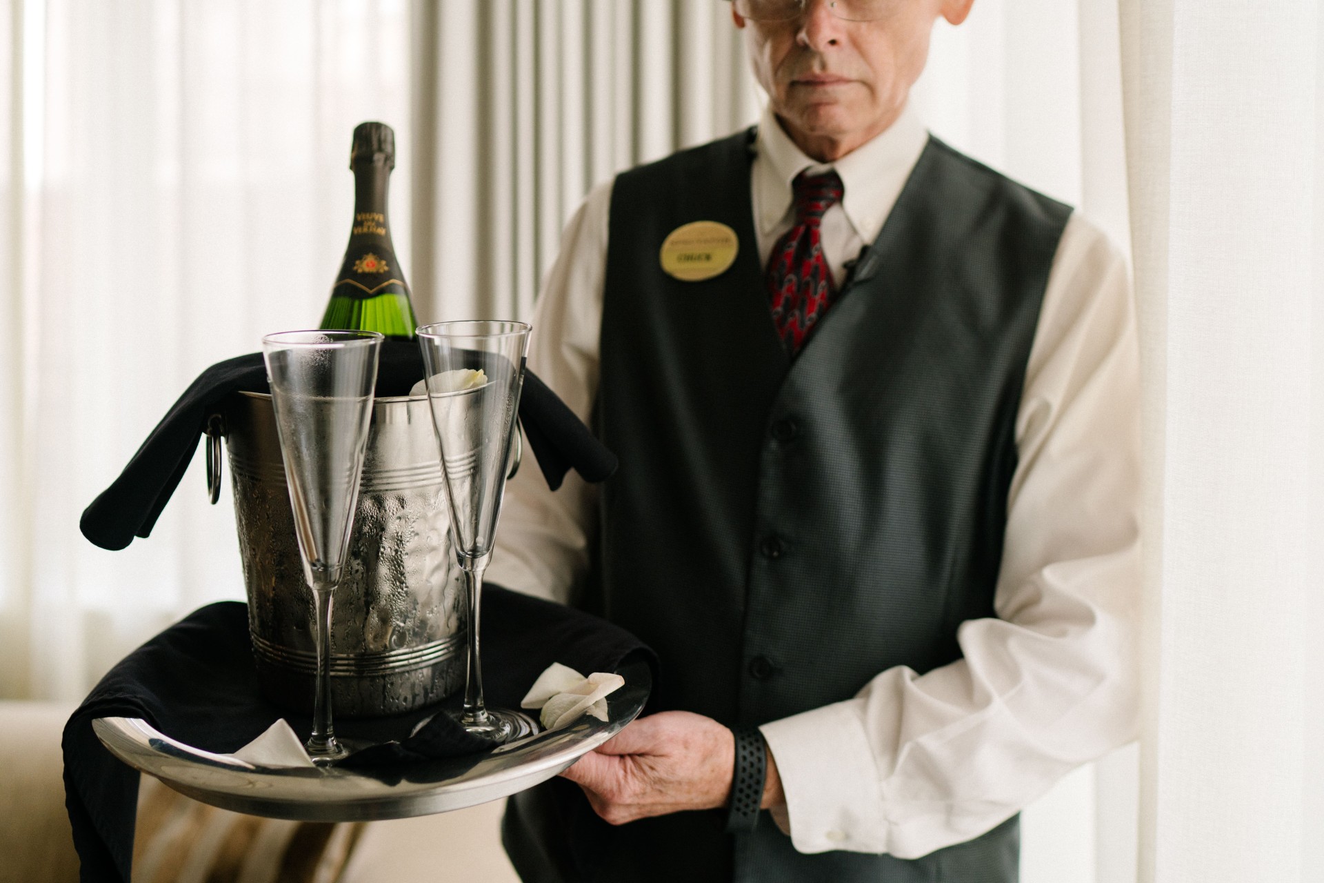 a man holding a tray with champagne and glasses