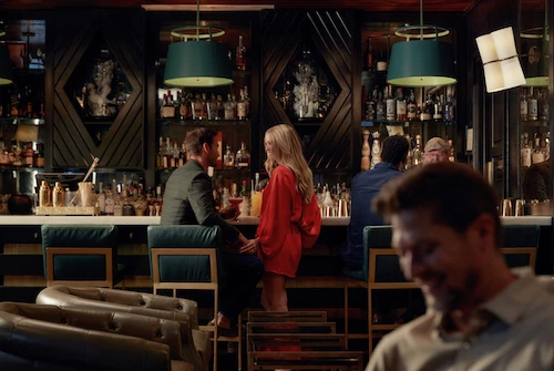 a man and woman sitting at a bar