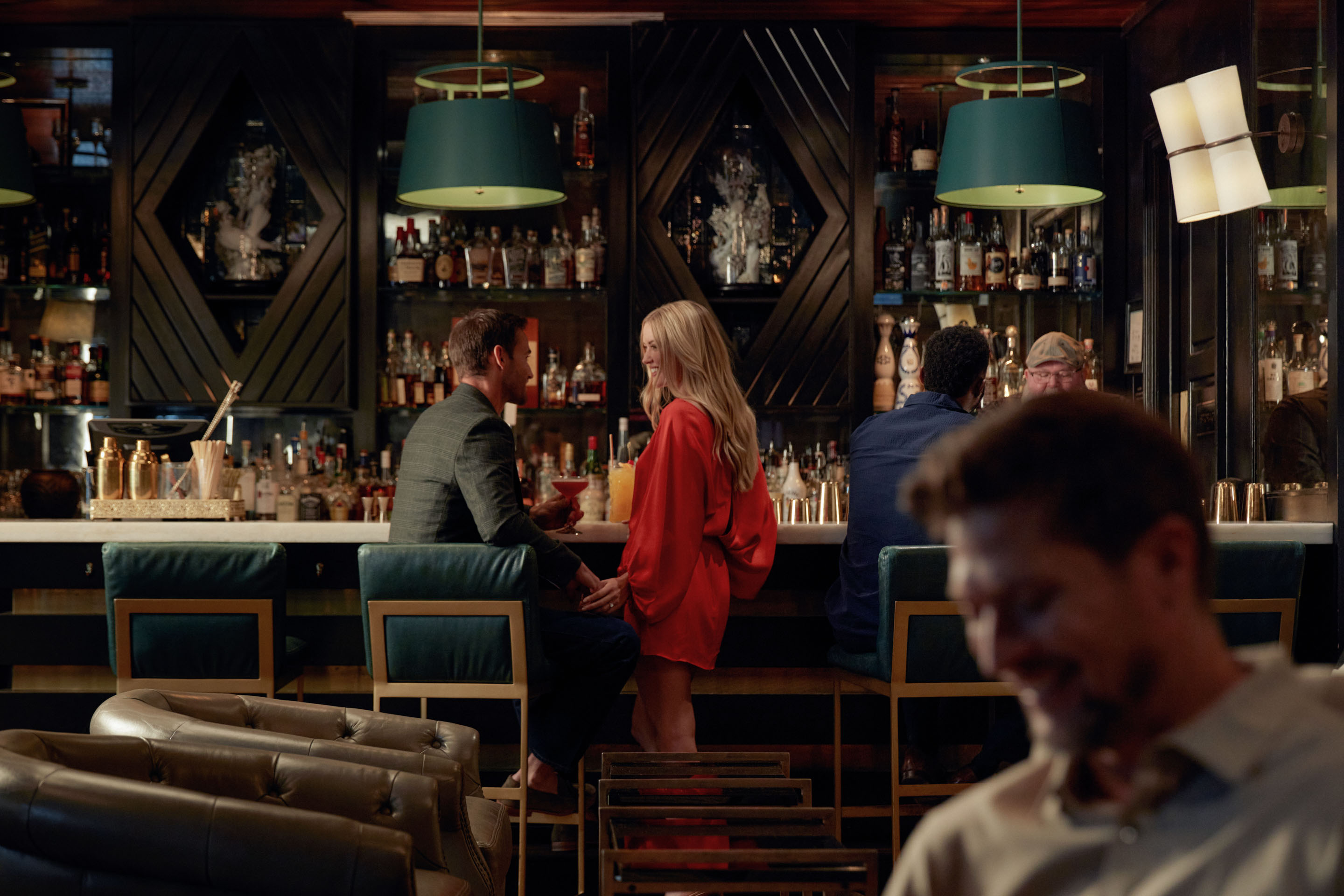 a man and woman sitting at a bar