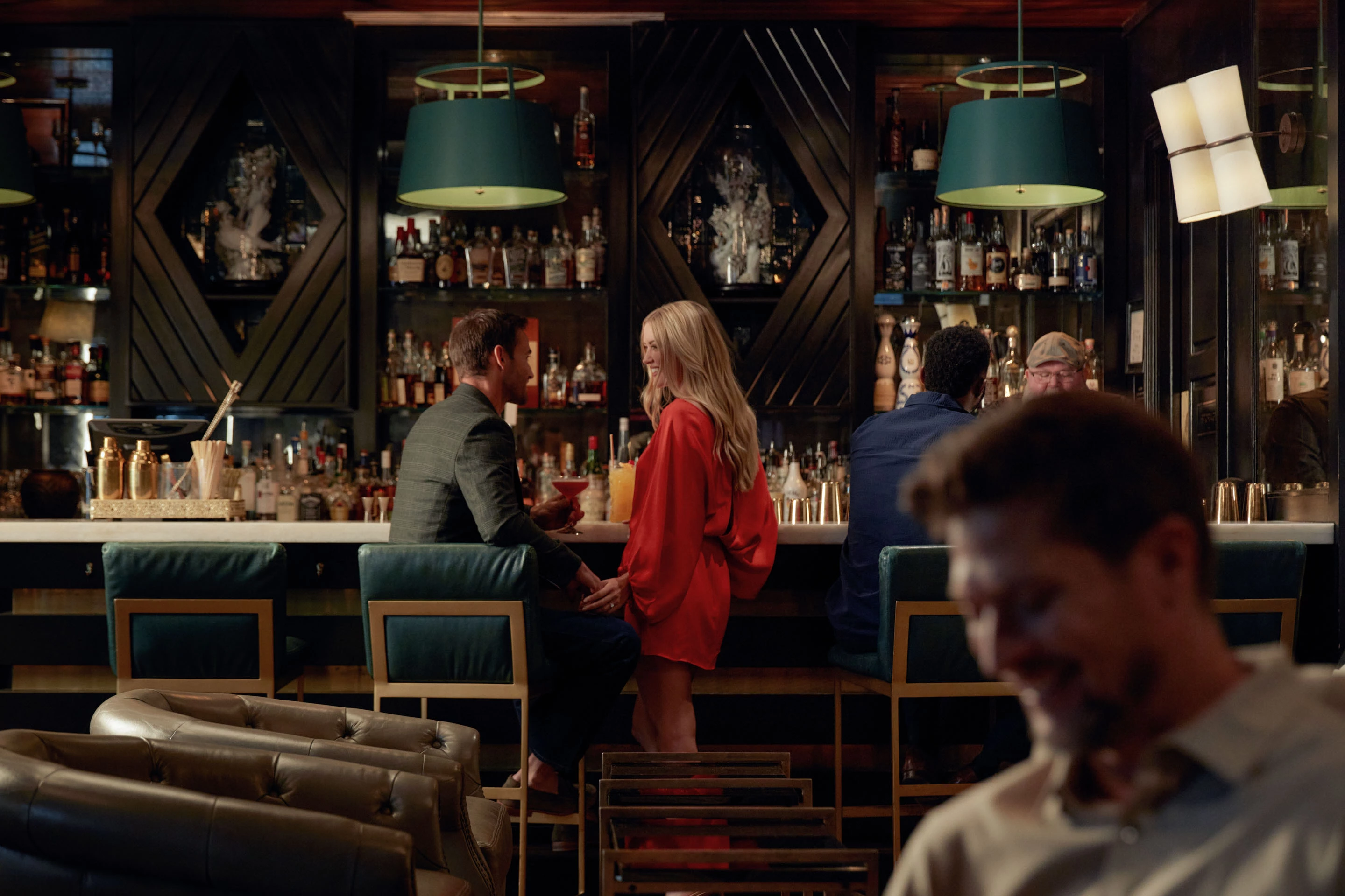 a man and woman sitting at a bar
