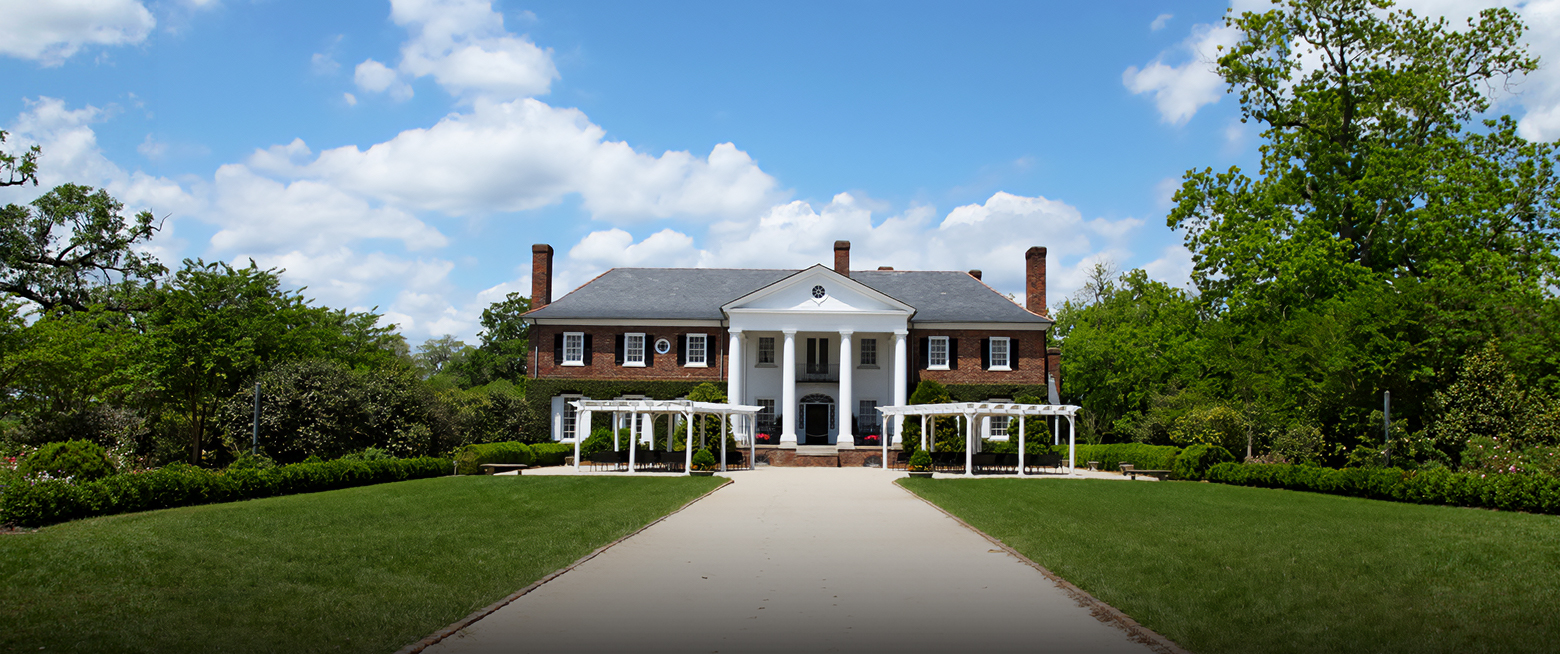 a large brick house with columns and a walkway