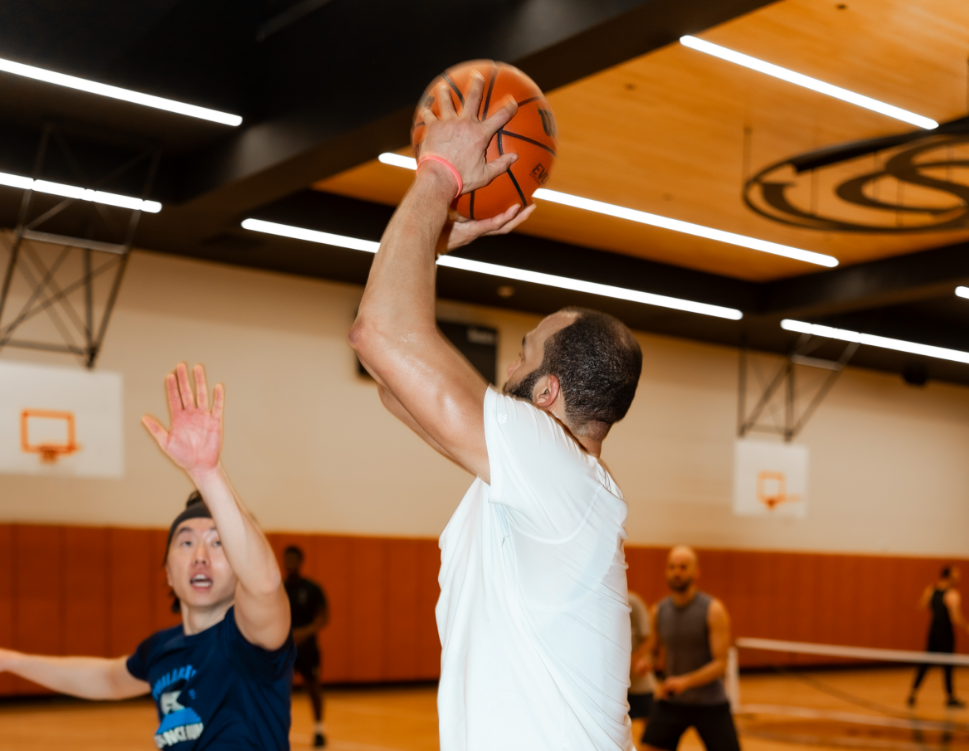 a man in a white shirt and white shirt with a basketball in the air